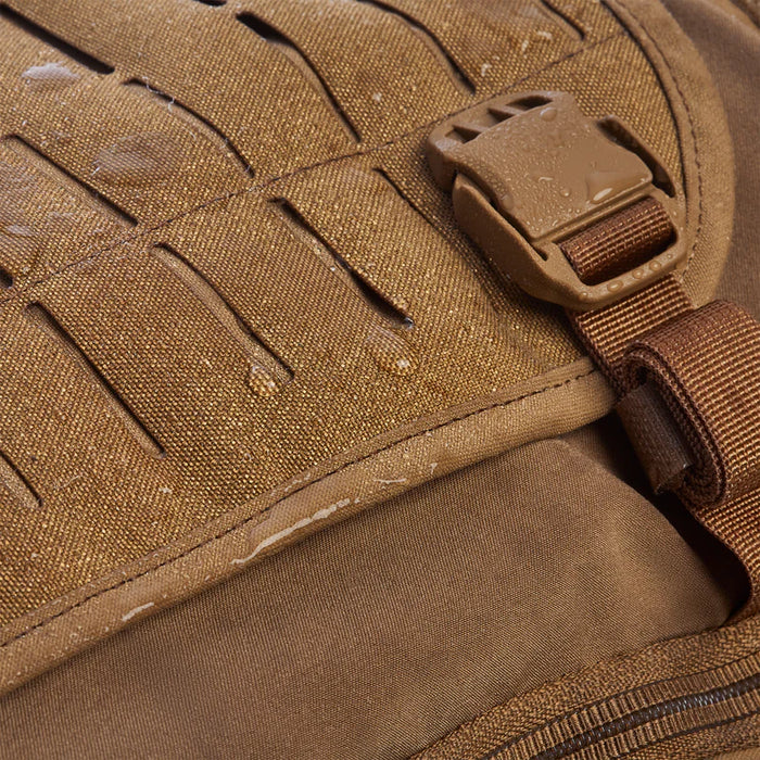 Close-up view of the expandable front pocket fabric repelling water on the Vertx Siege 15L Tactical Sling Bag in Coyote.