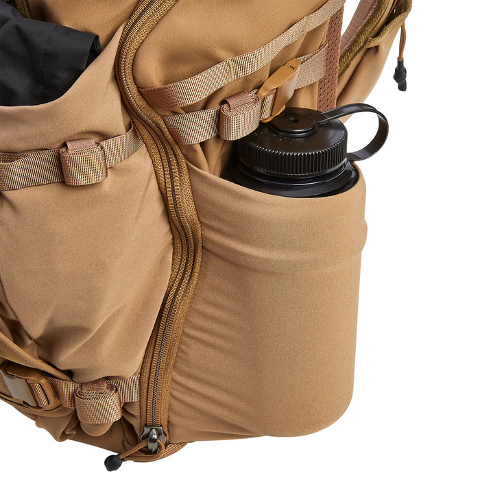 Close-up of the side pocket on the Vertx Siege 35L Pack demonstrating its expanding capability to securely hold large water bottles or tactical gear.